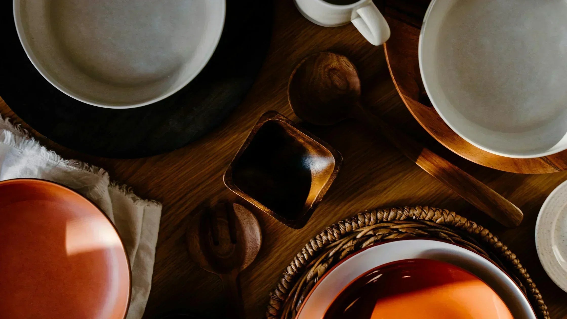 Japanese dining table with traditional serveware, ceramic plates, wooden utensils, and tea set for an authentic dining experience.