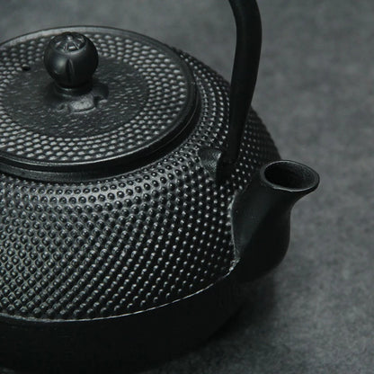 Japanese cast-iron teapot with tannin film covered interior, traditional design, and rust-resistant finish, perfect for brewing tea