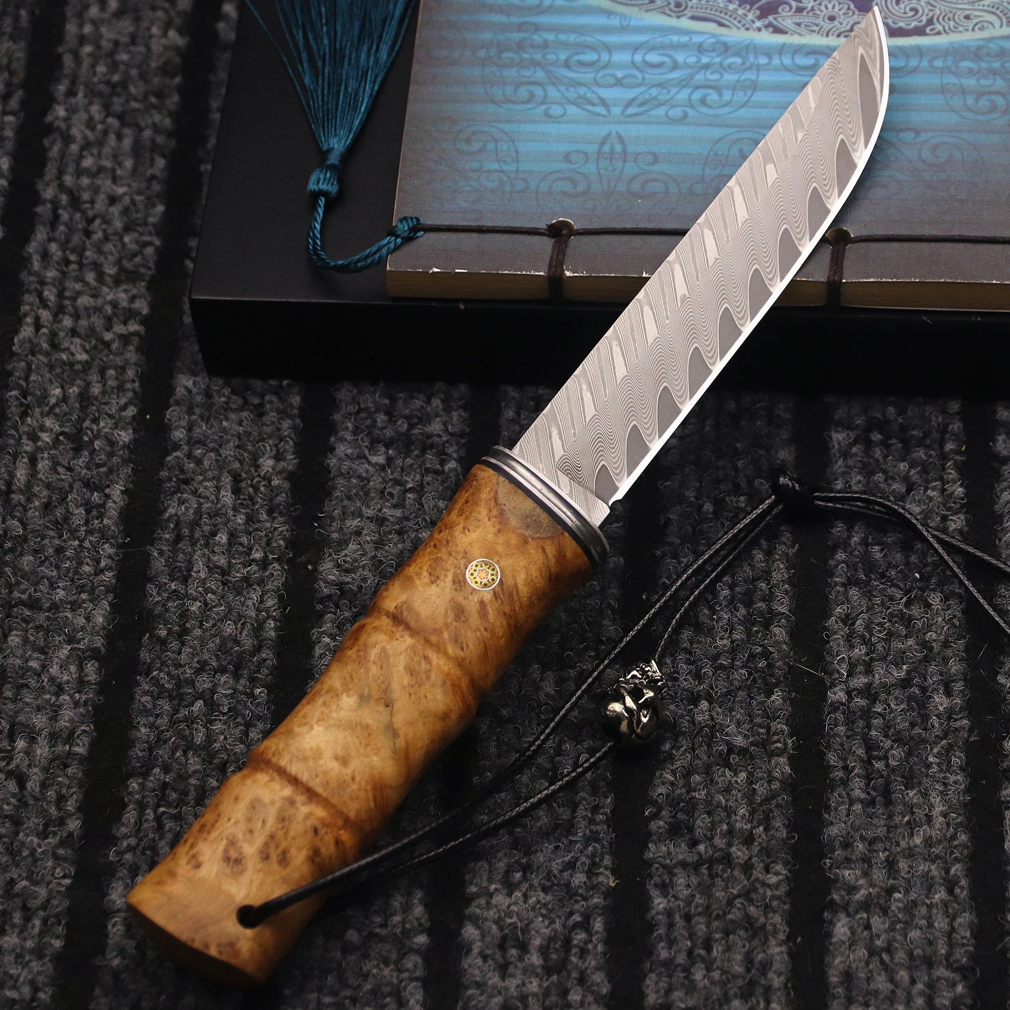 Japanese Damascus steel survival knife with bamboo-inspired handle, durable blade for outdoor adventures and bushcraft tasks.