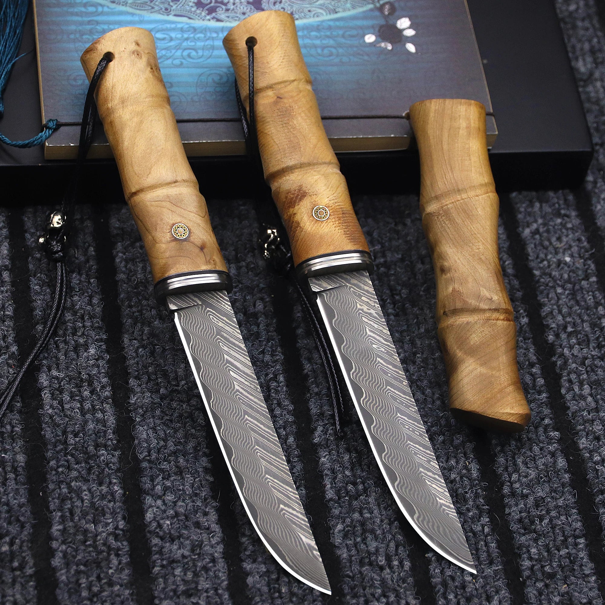 Japanese Damascus steel survival knife with bamboo-inspired handle, durable blade for outdoor adventures and bushcraft tasks.